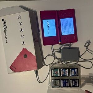 Pink Nintendo DS with multiple games and charger